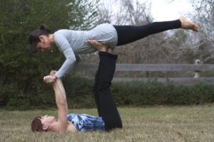 Sallie Anglin lifts Stevi Self in a demonstration of acro-yoga on the grounds of Rowan Oak.