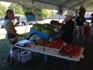 Josephine Alexander selling vegetables to a customer.