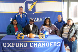 Linebacker Michael McGhee signed with University of North Alabama surrounded by his family and coach Hill.