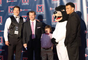 Defensive end John Youngblood, athletics director Ross Bjork and his son, Rebel the Black Bear and tight end Evan Ingram.