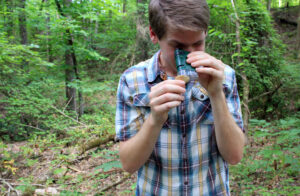 Taylor Brame inspects the mushroom with a pocket microscope.