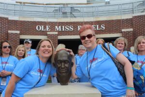 Michelle Flessas and a fiend pose with Chucky Mullins at Ladies' Football Forum.