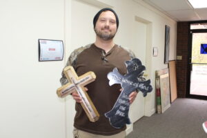 Neal Pettigrew holds two crosses made by the students at MHTC.