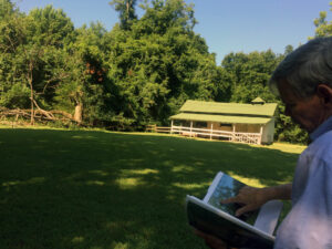Ed Croom finds a picture of the now-dead pecan tree that once stood next to the stables at Rowan Oak.