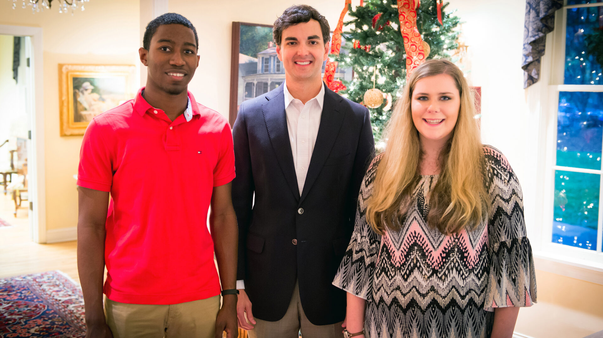 UM alumnus Jimmy Carr (center) greets his 2016 scholarship recipients, Pride of the South Marching Band members James Vinson (left) and Taylor Bost at Memory House. Photo by Bill Dabney