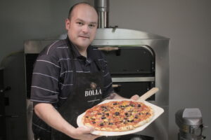 Brian Hernandez makes pizza in the office kitchen. 