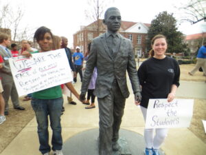 Student organizers pose with the James Meredith statue. 