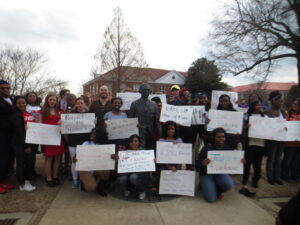 Students held their posters up at the James Meredith statue, during a peaceful protest against racist symbols and acts.