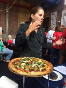 Karen Irby explains to judges that campers at Camp Lake Stephens grow all the toppings for her pizza.