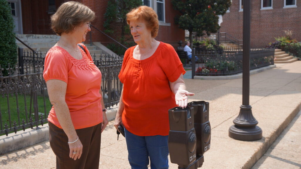 Beth Baggett, Deputy City Clerk, and her mother, Sandy Barnett, discuss the new parking meters being in stalled on the Square Thursday. 