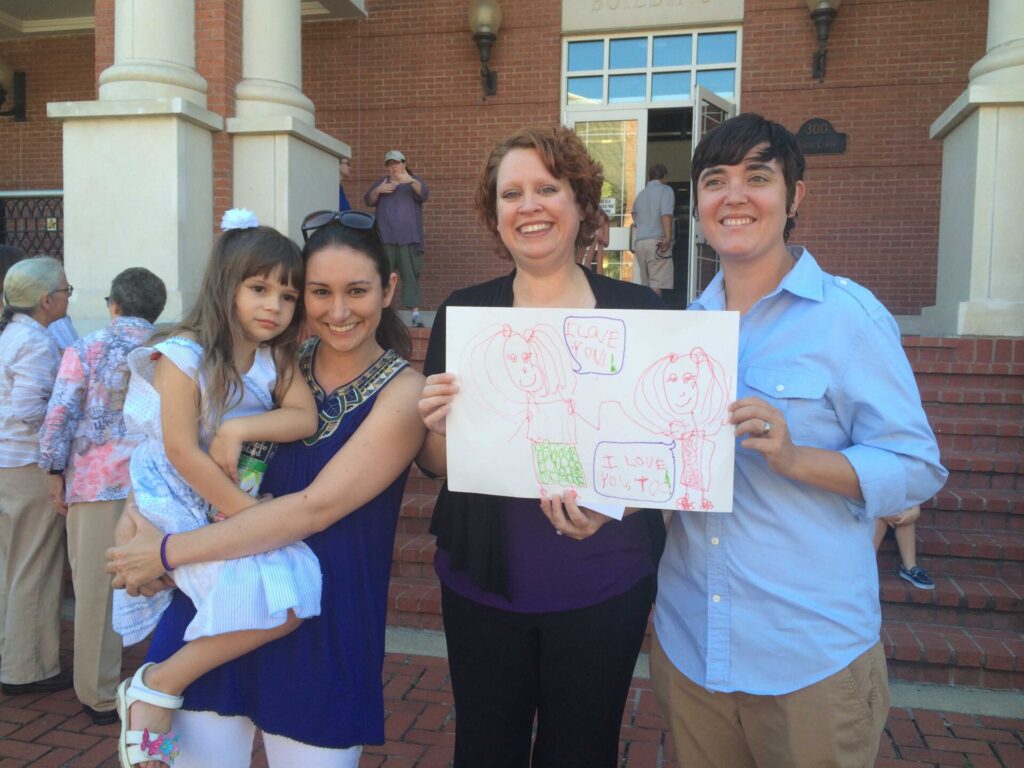 Stacey (left) and Anna (right) pose with an Oxonian named Alissa Davis with her 4 year old daughter, Virginia, who drew the picture for them.