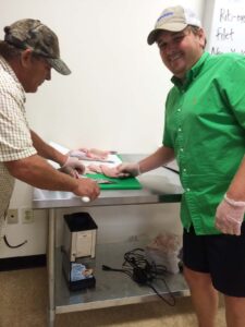 Russell Carson (left) and Indianola Fresh Market Owner Will Adams prepare catfish filets.