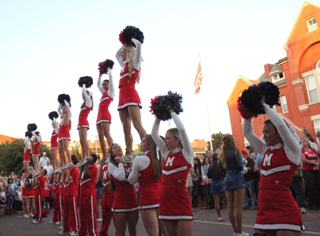 Cheerleaders host a pep rally in between the City Hall and the Courthouse. 