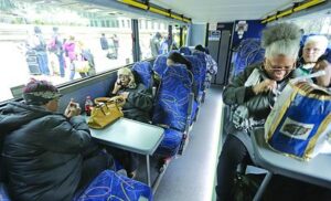 Megabus passengers sit at tables on the second story of the bus.