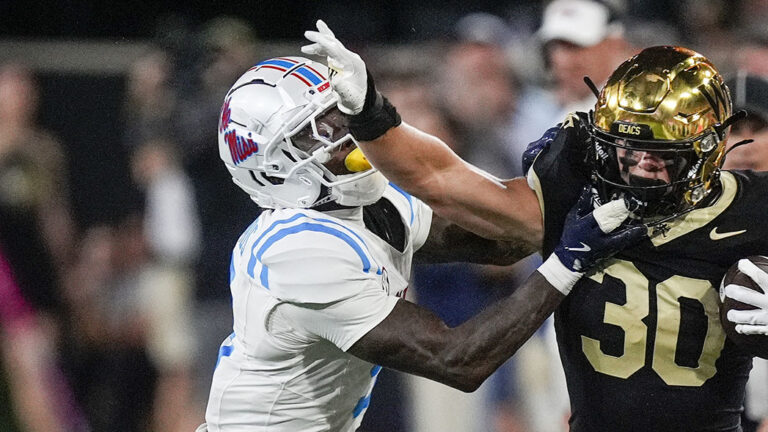 Wake Forest running back Tate Carney stiff arms Ole Miss cornerback Trey Amos