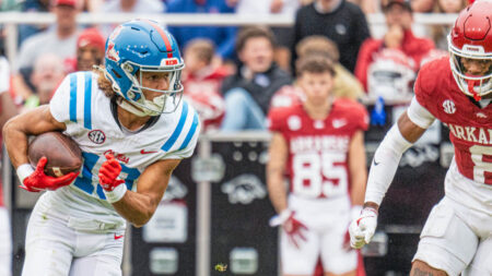 Rebels wide receiver Cayden Lee looks for running room after making a catch against Arkansas