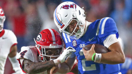 Ole Miss Rebels quarterback Jaxson Dart runs the ball as Georgia defensive back KJ Bolden