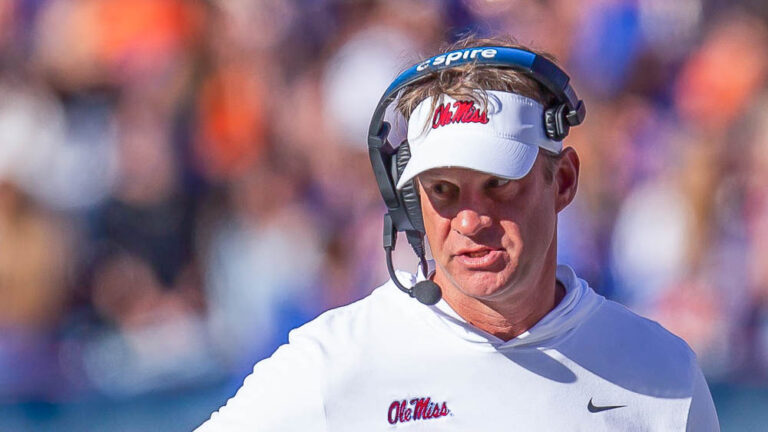 Rebels coach Lane Kiffin talks with his coaches during a timeout against Florida