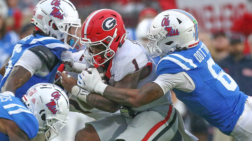 Georgia running back Trevor Etienne runs the ball as Ole Miss linebacker TJ Dottery (6) makes the tackle