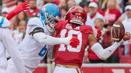 Razorbacks quarterback Taylen Green fumbles as he is hit by Ole Miss linebacker TJ Dottery