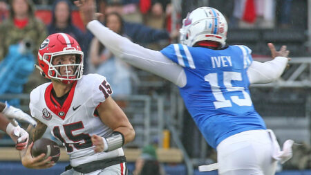 Georgia quarterback Carson Beck drops back to pass as Ole Miss defensive Jared Ivey