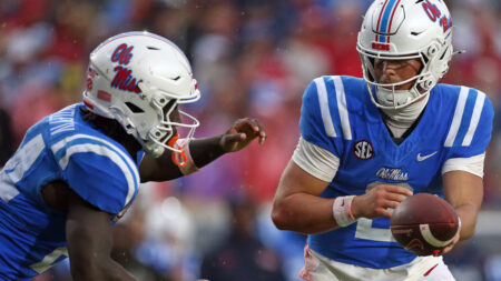 Rebels quarterback Jaxson Dart (2) hands the ball off to running back Ulysses Bentley IV (24) during the first half against Georgia