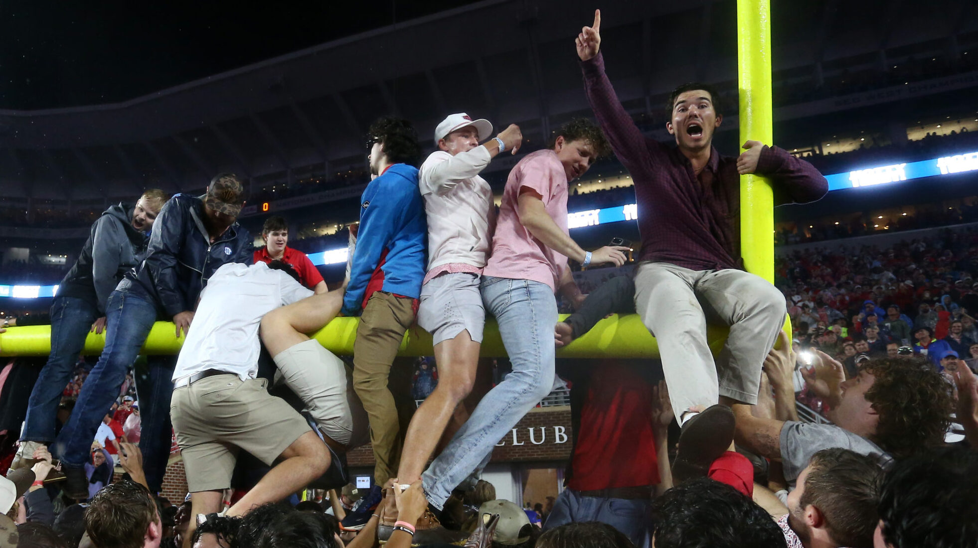 Ole Miss fans attempt to tear down the goal post after defeating Georgia