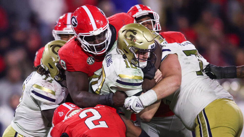 Georgia Tech Yellow Jackets quarterback Haynes King (10) is tackled by Georgia Bulldogs defensive lineman Nazir Stackhouse (78) and linebacker Smael Mondon Jr. (2)